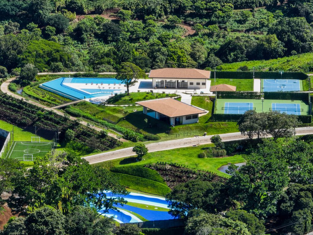 Vista áerea de las amenidades. Incluye la casa club, las canchas de tennis, de basket, de badminton, el gimnasio equipado, el salón multiuso para yoga, las piscinas, la cancha de futbol, y la pista surf skate. Condominio El Canal es un espacio para amantes del deporte, la naturaleza, el bienestar y el movimiento. Casas y apartamentos disponibles en preventa.
Vivir en paz
vivir rodeado de naturaleza
viviendas en costa rica
viviendas en condominio
casas en costa rica
apartamentos en costa rica
condominio el canal
comprar vivienda en costa rica
condominio el canal grecia
condominio montezuma
casas nuevas costa rica
comprar vivienda en costa rica
costa rica bienes raices
costa rica vivienda